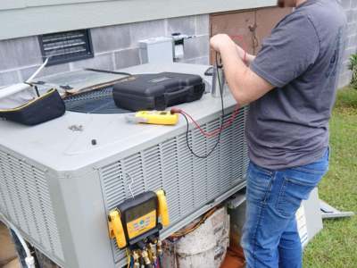 Engle Services HVAC Technician repairing an AC unit.
